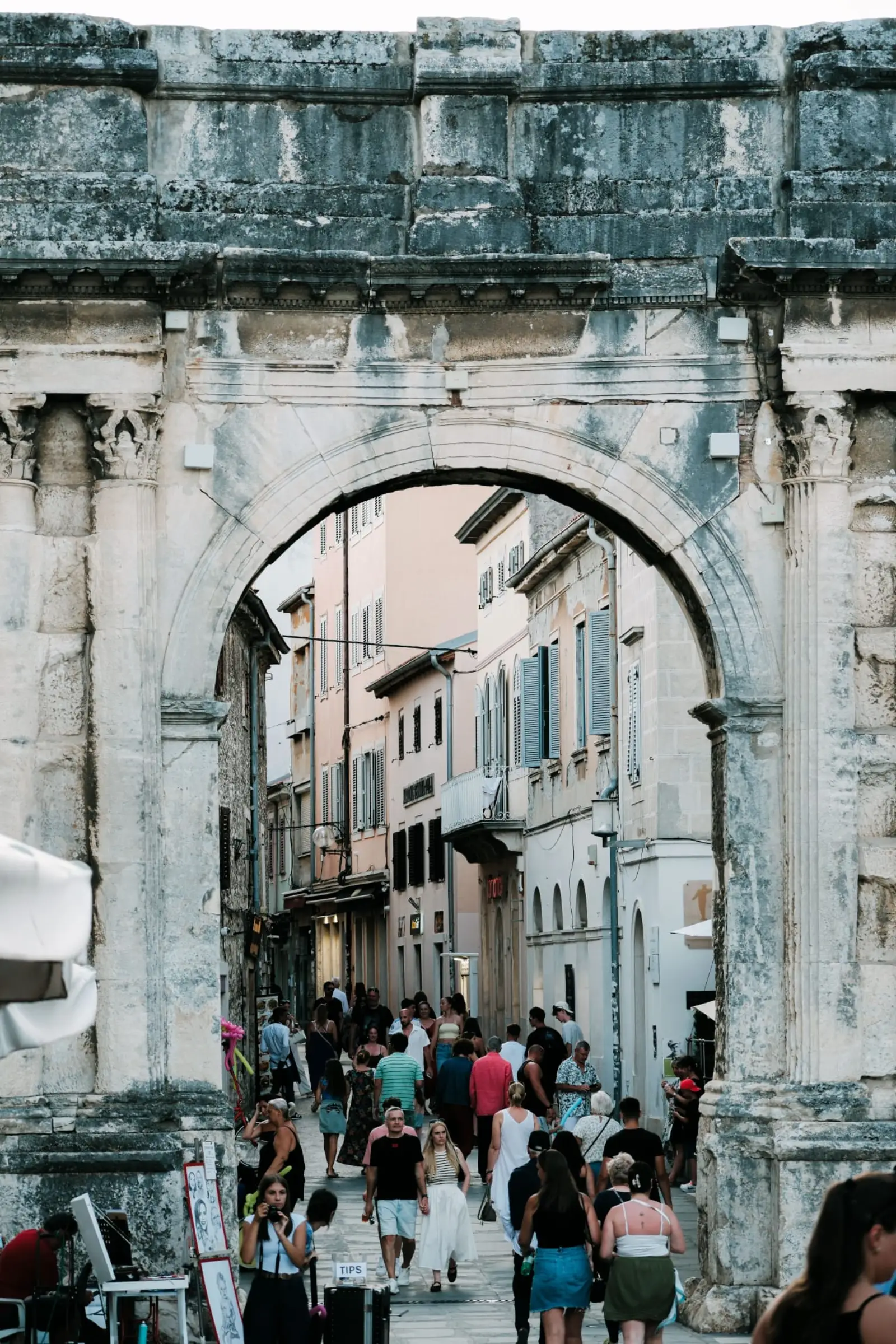 Pula's Arch of Sergii above a lively old-town street