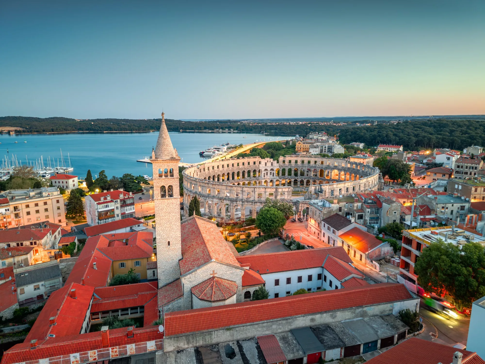 The Pula Arena and harbour at dusk, seen from above